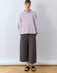 Full length view of the Sode Jersey Pullover in Lilac Purple with cotton jersey trousers.