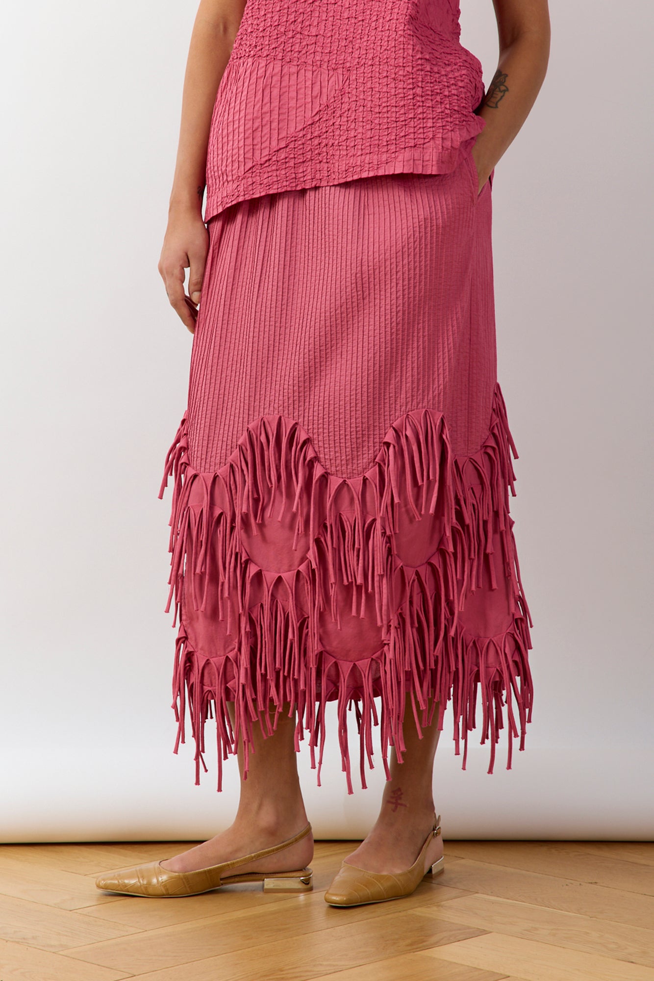 Side view of Dust Rose Kazari Skirt showing flowing silhouette and mid‑length design.