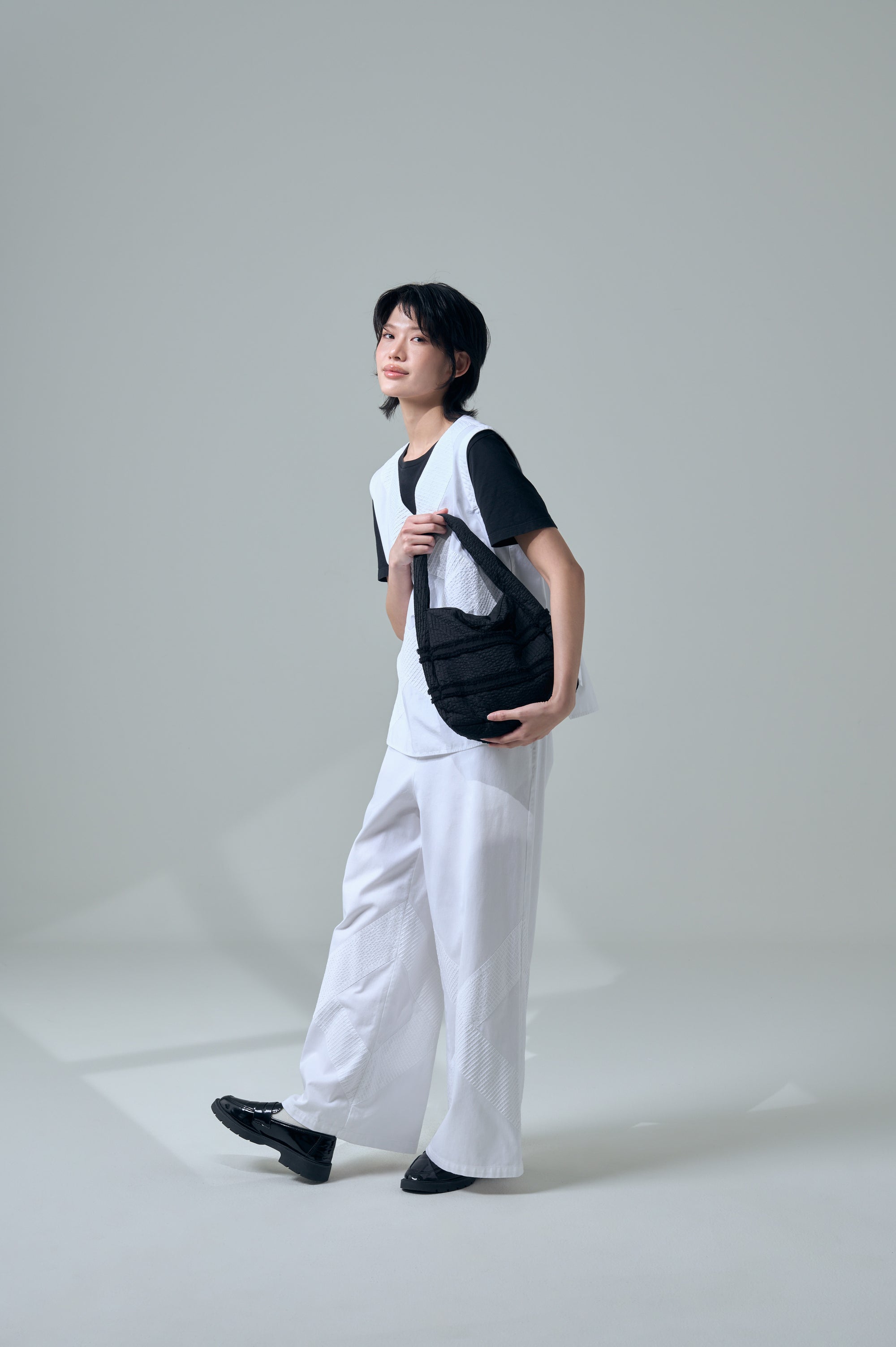 Model holding Zanpu bucket bag in black, by Yaccomaricard, elegant japanese design.