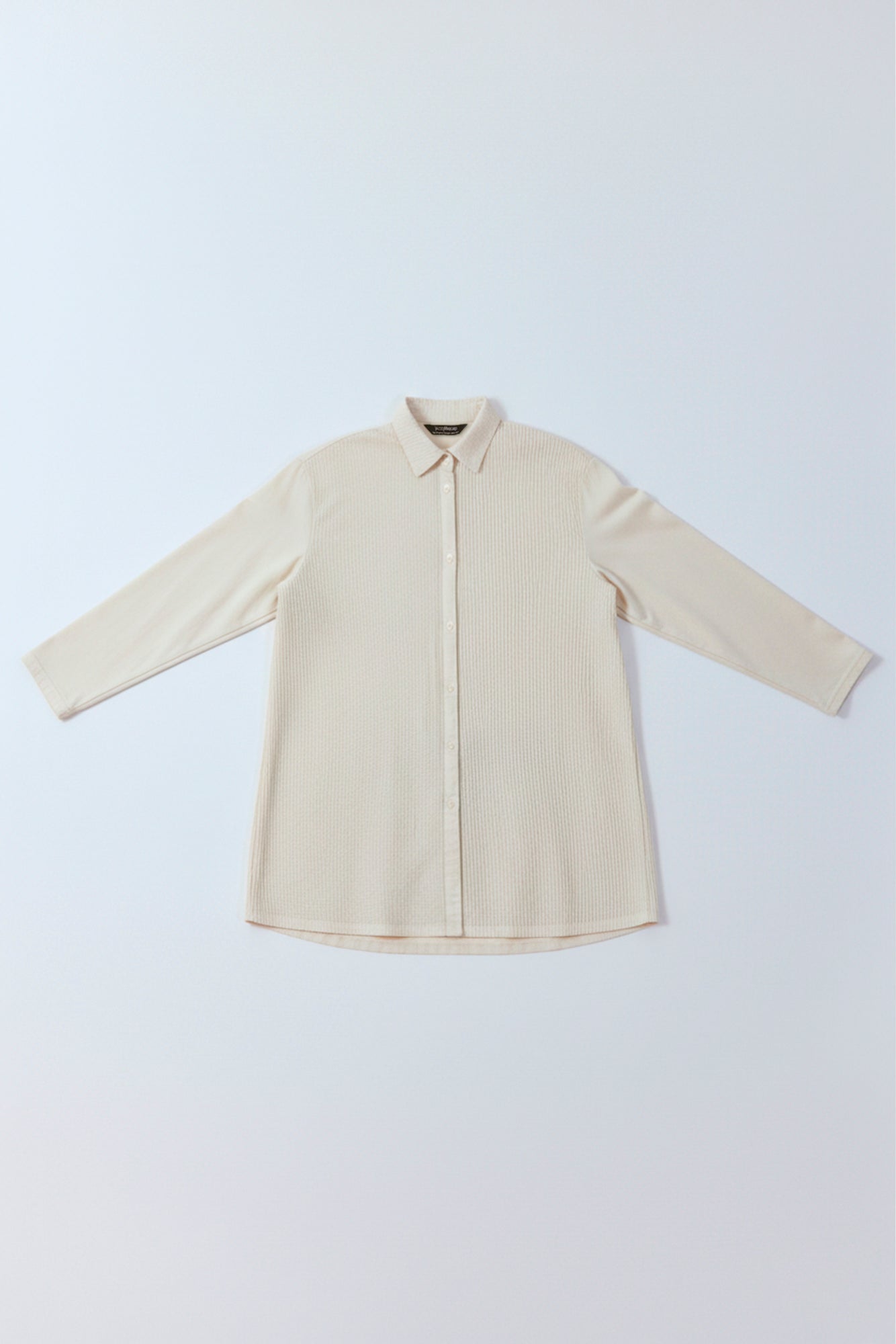 Flat lay of Yaccomaricard Cotton Jersey + Lawn A-line Overshirt in Jasmine White showing the different textures.